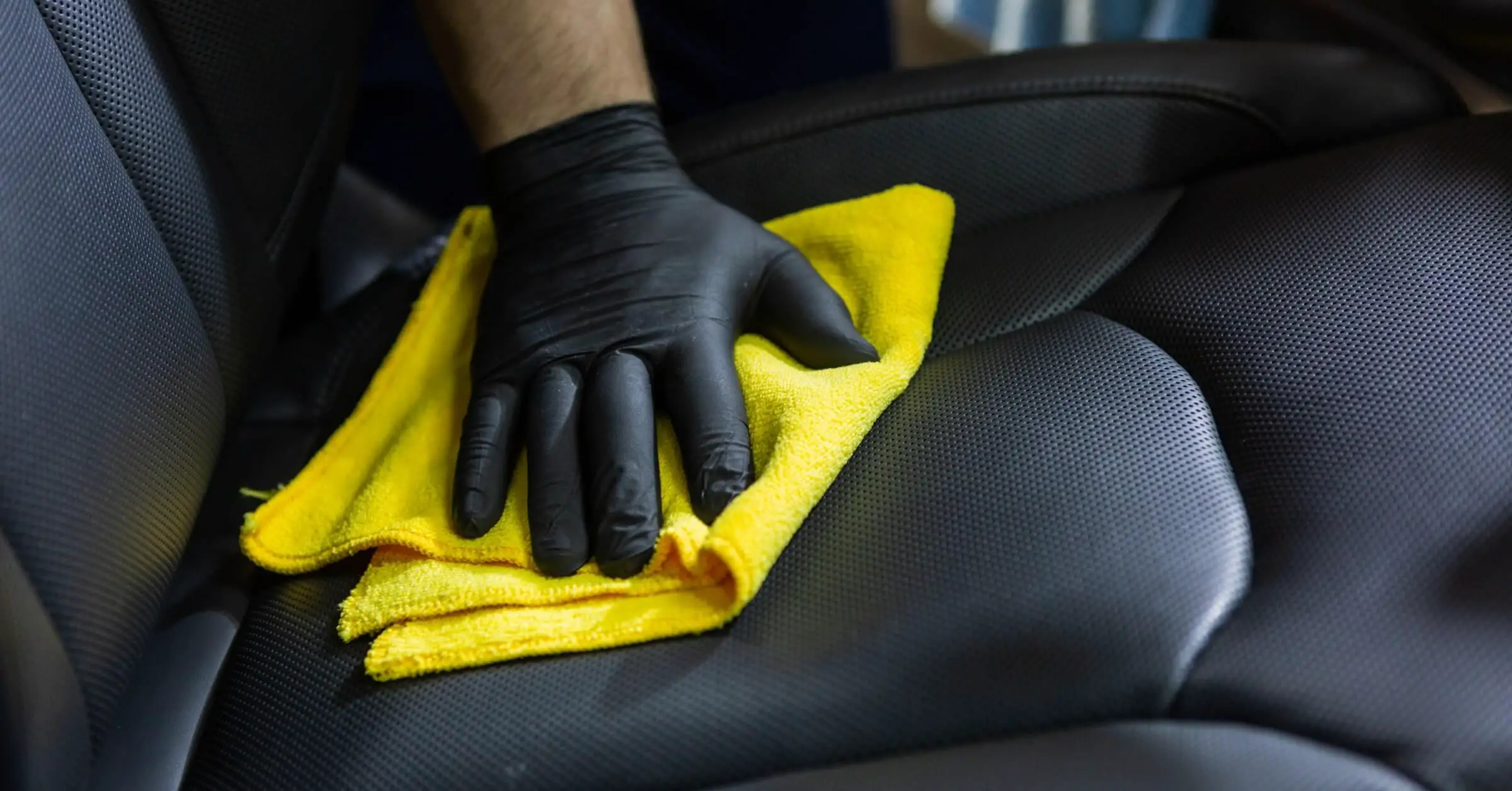 A car seat being wiped with a microfiber cloth